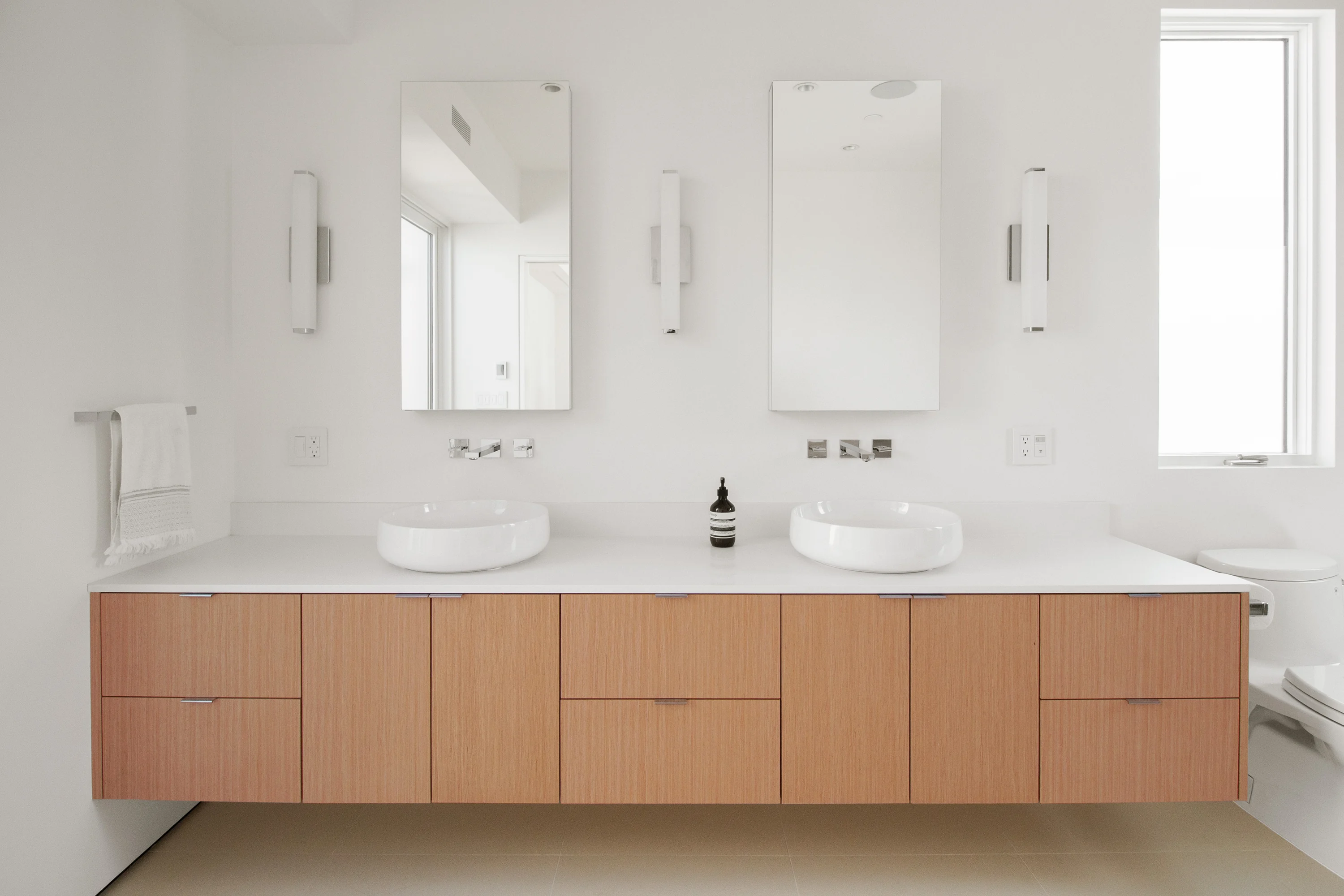Primary bathroom with a restrained palette of tile and wood